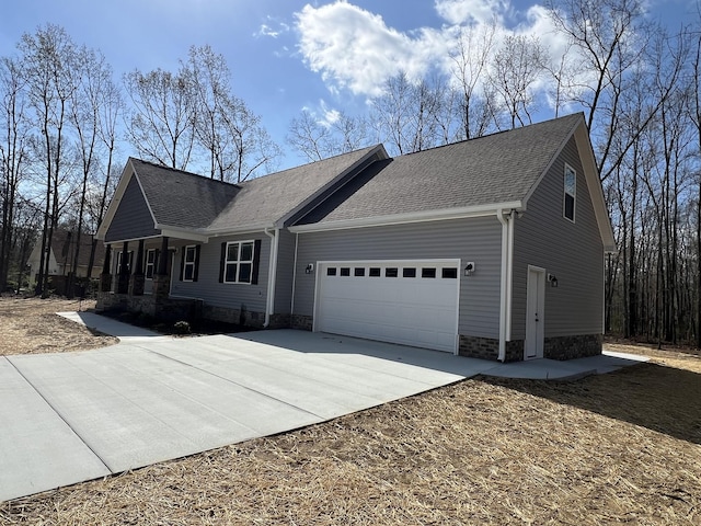 view of front of home featuring a shingled roof, an attached garage, stone siding, and concrete driveway