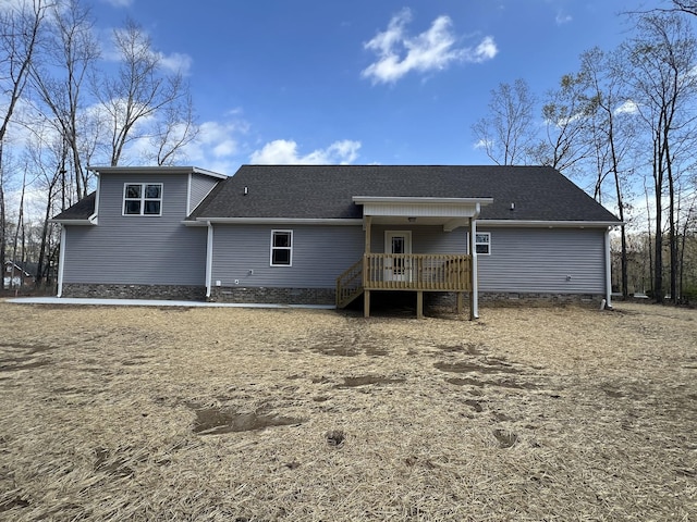 back of house featuring roof with shingles