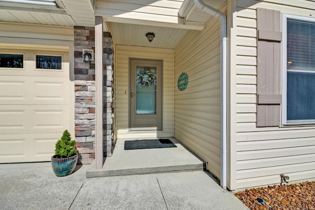 view of exterior entry with a garage and stone siding