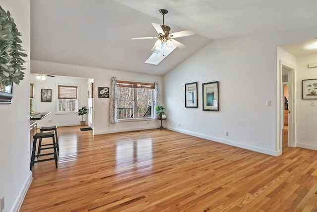 unfurnished living room featuring light wood-style floors, a wealth of natural light, and ceiling fan