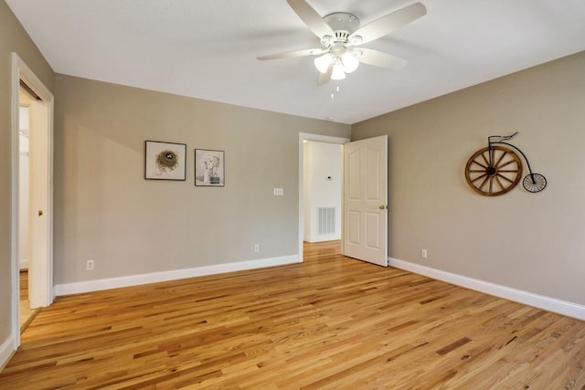 unfurnished room with light wood-type flooring, visible vents, ceiling fan, and baseboards