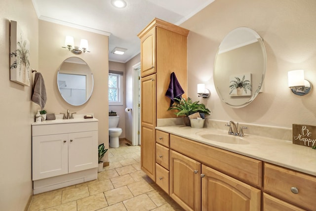 bathroom with crown molding, two vanities, a sink, and toilet