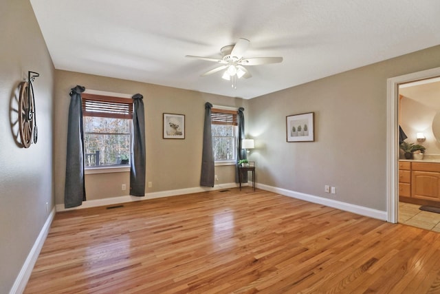 unfurnished room featuring baseboards, a healthy amount of sunlight, and light wood-style floors