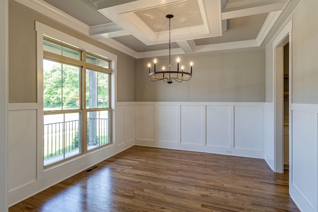 unfurnished dining area featuring a wainscoted wall, a chandelier, dark wood finished floors, and ornamental molding