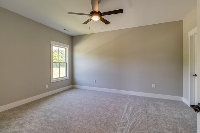 spare room featuring ceiling fan, carpet flooring, visible vents, and baseboards