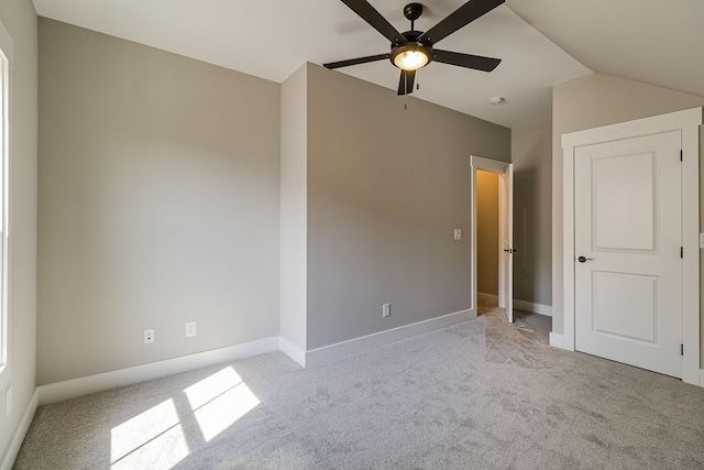 unfurnished bedroom with lofted ceiling, light carpet, ceiling fan, and baseboards