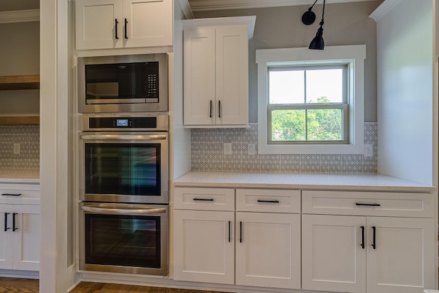 kitchen featuring light countertops, stainless steel double oven, white cabinetry, and built in microwave