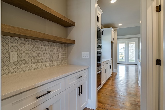 kitchen with open shelves, appliances with stainless steel finishes, white cabinets, and decorative backsplash