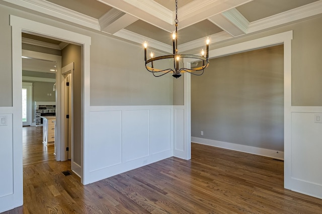 unfurnished dining area featuring coffered ceiling, a notable chandelier, dark wood-style flooring, and beam ceiling