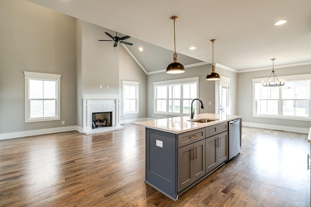 kitchen with a sink, open floor plan, a brick fireplace, gray cabinets, and dishwasher