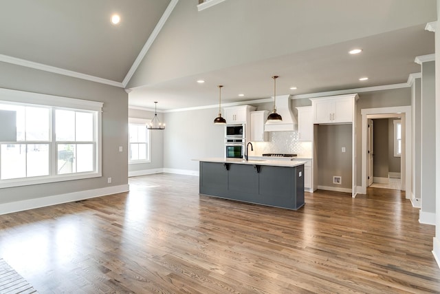 kitchen with a breakfast bar, white cabinetry, light countertops, stainless steel microwave, and custom range hood