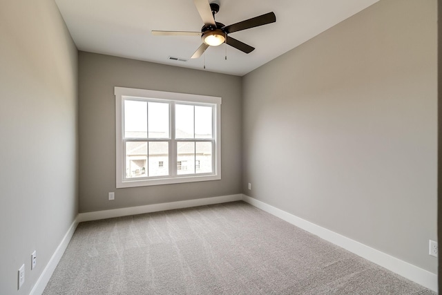 carpeted empty room featuring ceiling fan, visible vents, and baseboards