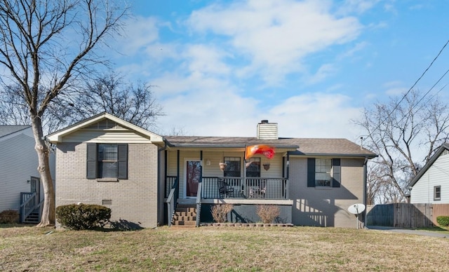 view of front of property featuring crawl space, covered porch, a front yard, and brick siding