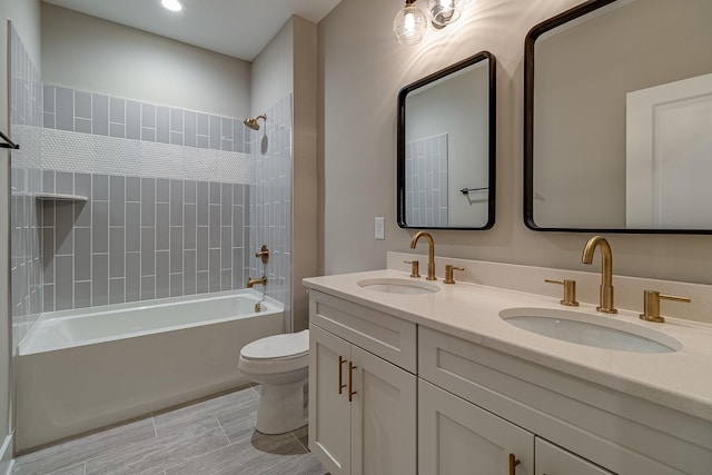 bathroom featuring toilet, shower / bath combination, double vanity, and a sink