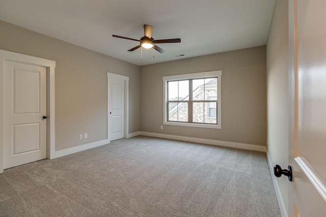 unfurnished room with visible vents, carpet, a ceiling fan, and baseboards