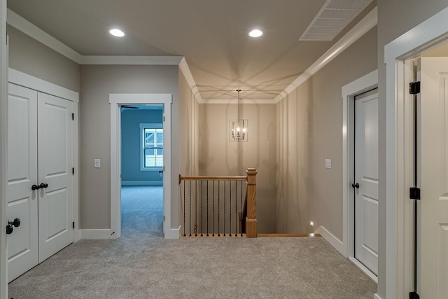 corridor featuring carpet, an upstairs landing, visible vents, and crown molding