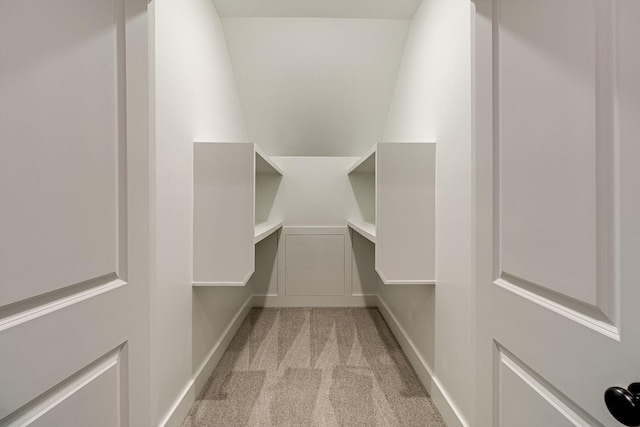 walk in closet featuring light carpet