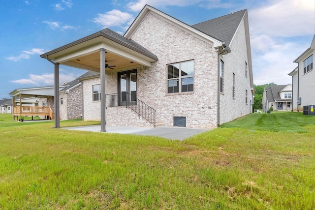 back of house featuring brick siding, a lawn, a patio area, and a ceiling fan