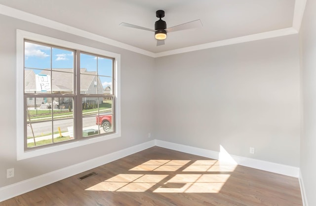 empty room with visible vents, ceiling fan, baseboards, and wood finished floors