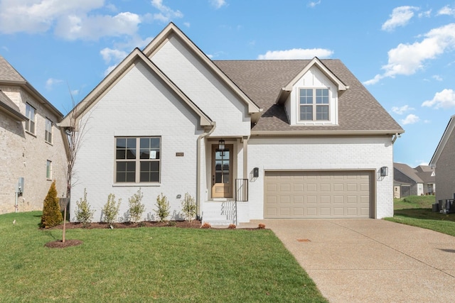 view of front of house featuring brick siding, roof with shingles, an attached garage, driveway, and a front lawn