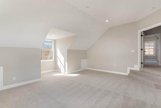 bonus room featuring carpet, vaulted ceiling, plenty of natural light, and baseboards