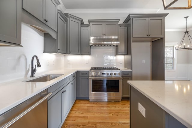 kitchen featuring gray cabinets, appliances with stainless steel finishes, ornamental molding, a sink, and under cabinet range hood