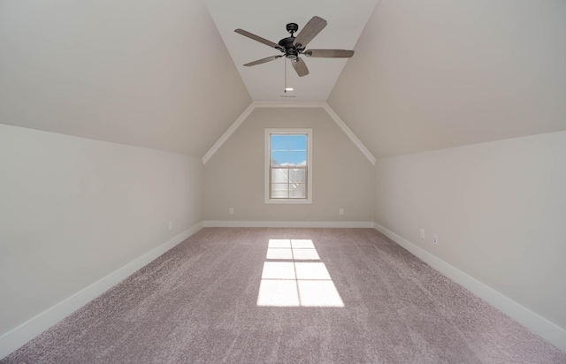 additional living space featuring lofted ceiling, baseboards, a ceiling fan, and light colored carpet