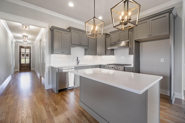 kitchen featuring gray cabinetry, ornamental molding, a sink, dishwasher, and under cabinet range hood