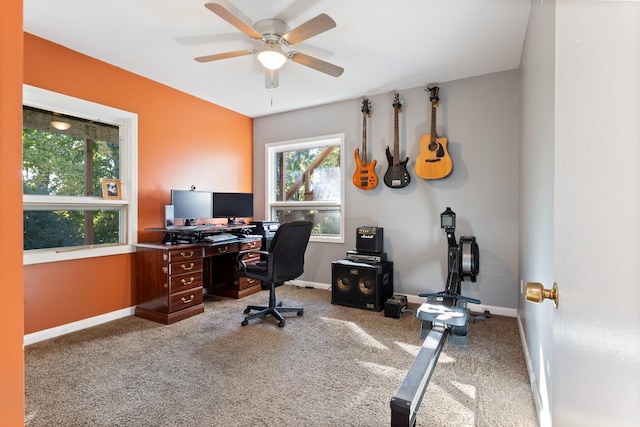 carpeted office with a ceiling fan and baseboards