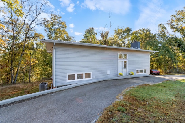 view of property exterior with a chimney and central air condition unit