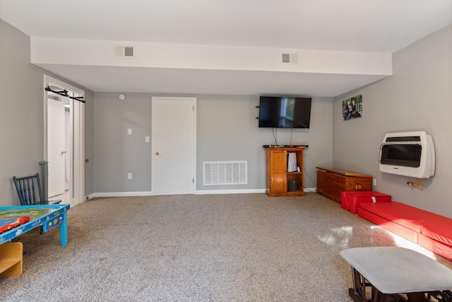 rec room with baseboards, visible vents, and heating unit