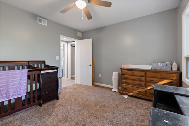 carpeted bedroom with baseboards, visible vents, and a ceiling fan