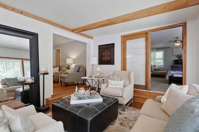 living room with beamed ceiling and light wood-style flooring