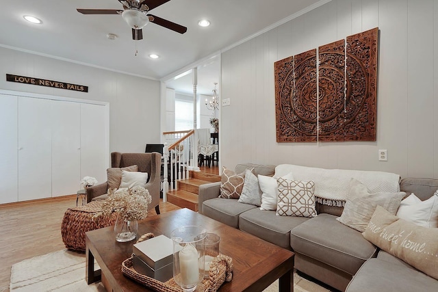 living area featuring ceiling fan with notable chandelier, ornamental molding, light wood-style flooring, and recessed lighting