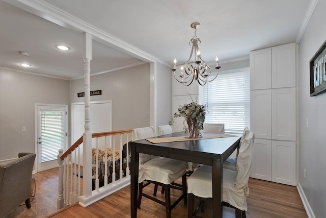 dining area with baseboards, crown molding, an inviting chandelier, and wood finished floors