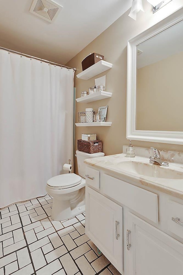 full bathroom featuring curtained shower, visible vents, vanity, and toilet