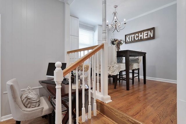 staircase with an inviting chandelier, baseboards, ornamental molding, and wood finished floors