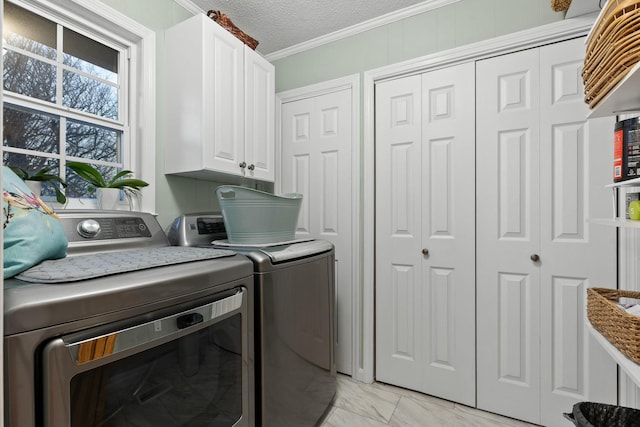 laundry room with cabinet space, washing machine and clothes dryer, marble finish floor, crown molding, and a textured ceiling