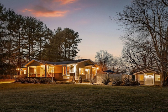 view of front of house with a yard, a porch, and fence