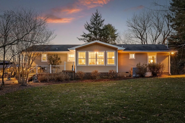 rear view of property with crawl space, a lawn, and a wooden deck