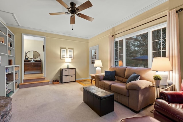 living room with ornamental molding, carpet floors, and a ceiling fan