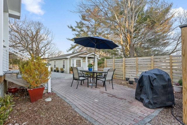 view of patio featuring outdoor dining area, a fenced backyard, and grilling area