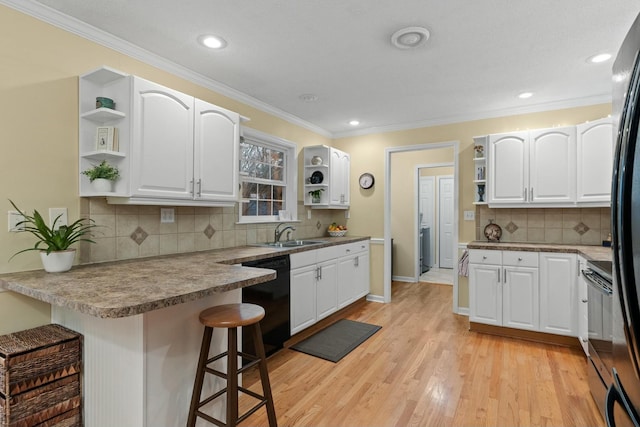 kitchen featuring dishwasher, a peninsula, a kitchen bar, open shelves, and a sink