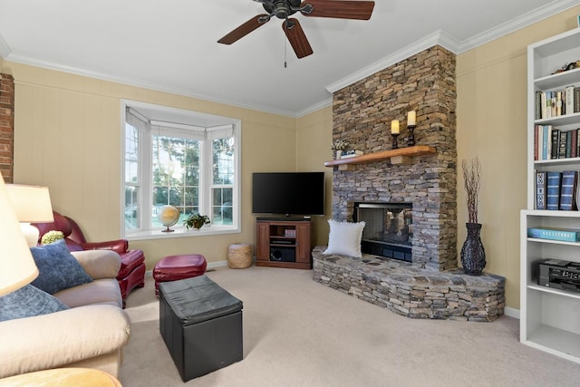 living area featuring ornamental molding, a fireplace, carpet floors, and a ceiling fan