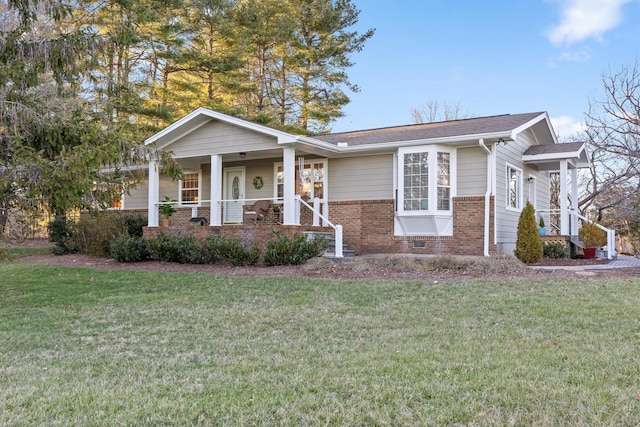 view of front of home featuring a front yard, a porch, and brick siding