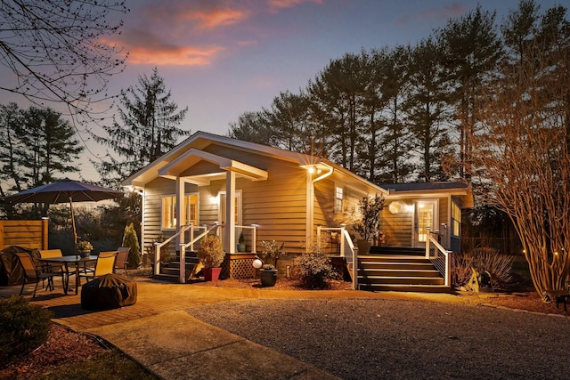 back of house at dusk featuring a patio area