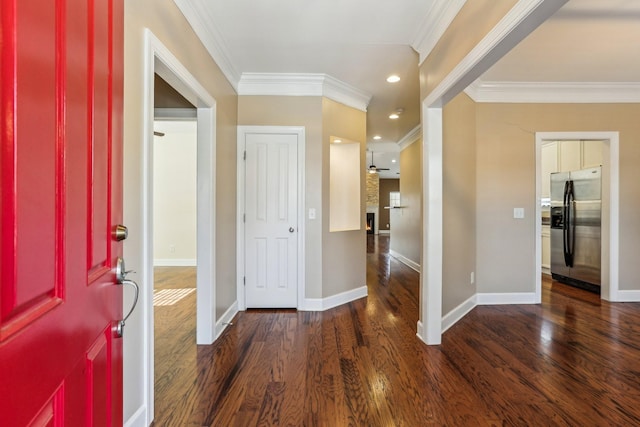 entryway featuring baseboards, ornamental molding, wood finished floors, and recessed lighting