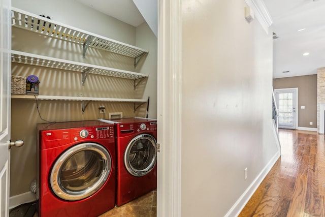 clothes washing area with washer and clothes dryer, recessed lighting, wood finished floors, laundry area, and baseboards