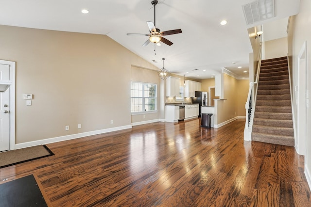 unfurnished living room featuring visible vents, lofted ceiling, dark wood-style floors, ceiling fan, and stairway