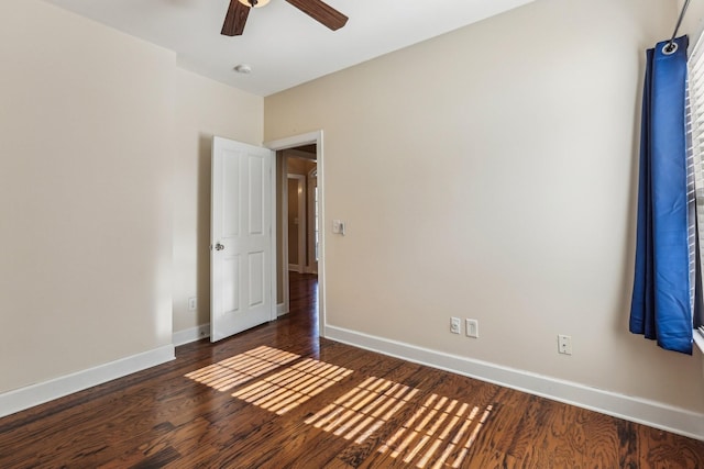 unfurnished room featuring ceiling fan, dark wood-style flooring, and baseboards